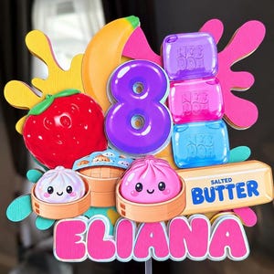 May include: A colorful cake topper featuring a large purple number 8, a red strawberry, a yellow banana, three Nee Doh sensory cubes, two dim sum dumplings in bamboo steamers, and a butter stick labeled Salted Butter with the name Eliana.