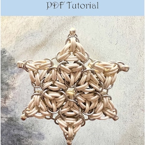 May include: A white snowflake star ornament made of metal rings. The ornament has a silver finish and is designed to hang from a ceiling or tree.