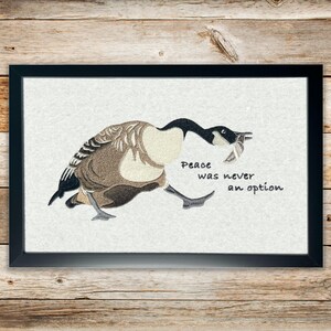 Silly Goose wall art with embroidered Canadian goose carrying a knife – Peace Was Never an Option.