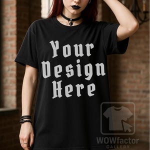 Könnte beinhalten: Schwarzes T-Shirt mit dem Text "Your Design Here" in einer gotischen Schriftart. Das Bild enthält das WOWfactor GALLERY-Logo. Das T-Shirt hat einen Rundhalsausschnitt.