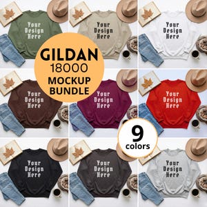 以下が含まれることがあります： 9色のGildan 18000スウェットシャツのモックアップバンドル。各スウェットシャツには前面に「Your Design Here」の文字がプリントされています。画像には、ジーンズ、帽子、コーヒーカップ、秋をテーマにした装飾も含まれています。