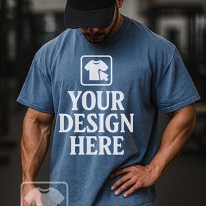 Può includere: Una maglietta blu con la scritta bianca "YOUR DESIGN HERE", sotto un'icona di maglietta bianca. La persona nell'immagine indossa un berretto da baseball nero e pantaloncini grigi. L'angolo in basso a sinistra dell'immagine ha la scritta "WOWfactor GALLERY".