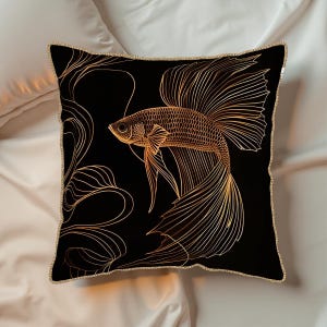 May include: Black square decorative pillow featuring a gold betta fish design. The fish is intricately detailed with flowing fins and tail. The pillow has a gold trim and a black background, creating a striking contrast.