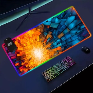 May include: A rectangular gaming mouse pad with a vibrant abstract design in orange, blue, and yellow. The pad has a colorful LED border and includes a remote, keyboard, and mouse.