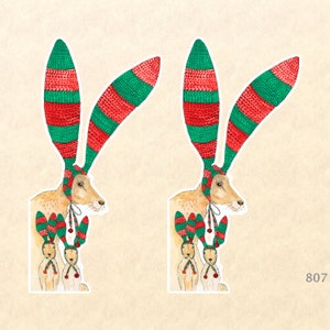 May include: Two illustrations of a brown rabbit wearing a red and green knitted hat with two smaller rabbits wearing similar hats. The rabbits are all facing forward with their ears up.