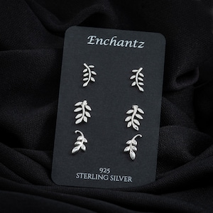 May include: A set of six silver leaf stud earrings on a black card with the text "Enchantz 925 Sterling Silver".