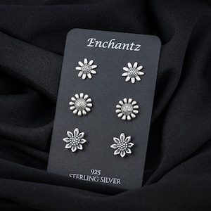 May include: Six silver flower stud earrings on a black card with the text "Enchantz 925 Sterling Silver".