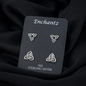 May include: A set of four silver Celtic knot earrings on a black card with the text "Enchantz 925 Sterling Silver".