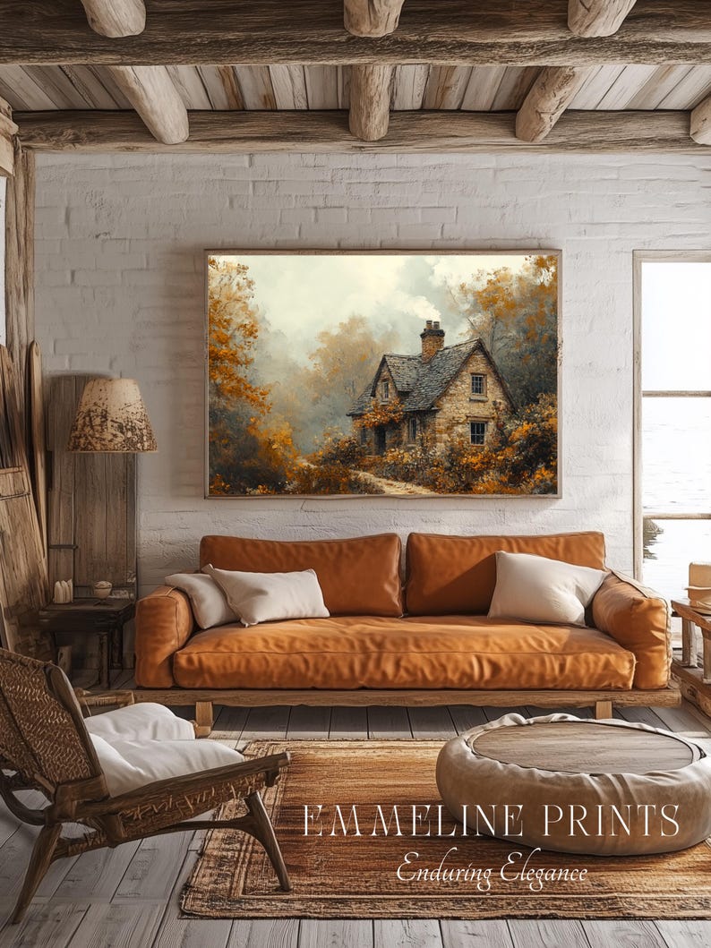 May include: A cozy living room scene featuring a framed landscape painting above a brown leather sofa with white pillows. A wooden chair, a round coffee table, and a patterned rug complete the warm, inviting space. The text "EMMELINE PRINTS Enduring Elegance" is visible.