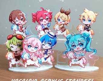 May include: A collection of eight chibi-style acrylic standees featuring various characters riding small white horses. The figures are arranged on two circular bases. Text at the top reads BUILD YOUR OWN and at the bottom reads VOCALOID ACRYLIC STANDEE!