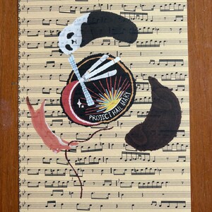 May include: A rectangular print featuring a beige background with black musical notation. Centered is a circular emblem with the text PROJECT HAIL MARY, surrounded by a panda, a brown animal, and a reddish-brown animal on a thin red string.