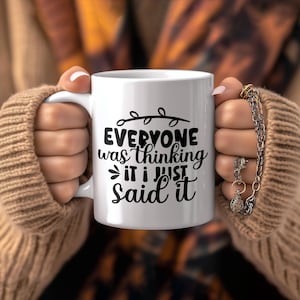 Könnte beinhalten: Eine weiße Keramik-Kaffeetasse mit einem schwarzen Design, auf dem "Everyone was thinking it I just said it" steht.