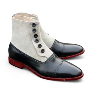 以下が含まれることがあります： 白いキャンバスのアッパーと赤いステッチが付いた黒い革のアンクルブーツ。ブーツは前面にボタン留めがあります。