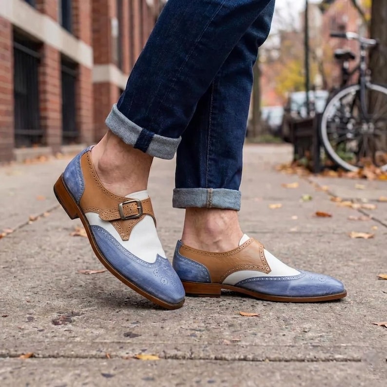 Handmade blue and white spectator monk strap shoes for men featuring premium leather construction, elegant brogue detailing, and artisan craftsmanship.

Two tone monk strap dress shoes crafted from genuine cowhide leather with vintage-inspired formal styling and durable leather sole.

Elegant handmade men’s formal shoes featuring blue leather finish, white contrast panels, monk buckle closure, and handcrafted detailing.