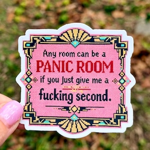 May include: A rectangular sticker with a pink background and a black and gold geometric border. The text reads: Any room can be a PANIC ROOM if you just give me a fucking second. The design features a cross-stitch style pattern throughout.