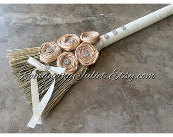 Timeless Elegance Wedding Broom with Vibrant Crystal Accents and Delicate Hand Rolled Rosettes.. Shown in Ivory with Champagne Rosettes