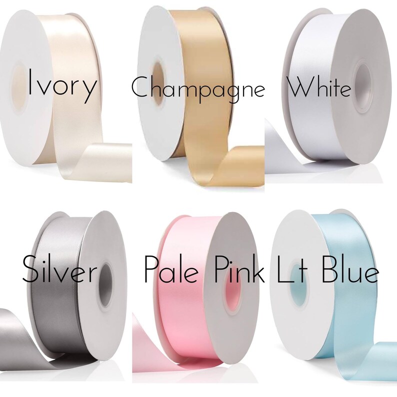 May include: Six spools of ribbon in various colors, including ivory, champagne, white, silver, pale pink, and light blue. The ribbon is wrapped around the spools and the colors are clearly visible.