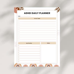 May include: ADHD Daily Planner in a neutral colour scheme. The planner features sections for To-Do/Tasks, My Priorities, and Notes. Decorative elements include a rainbow and leaf design. The text "ADHD Daily Planner" is at the top.