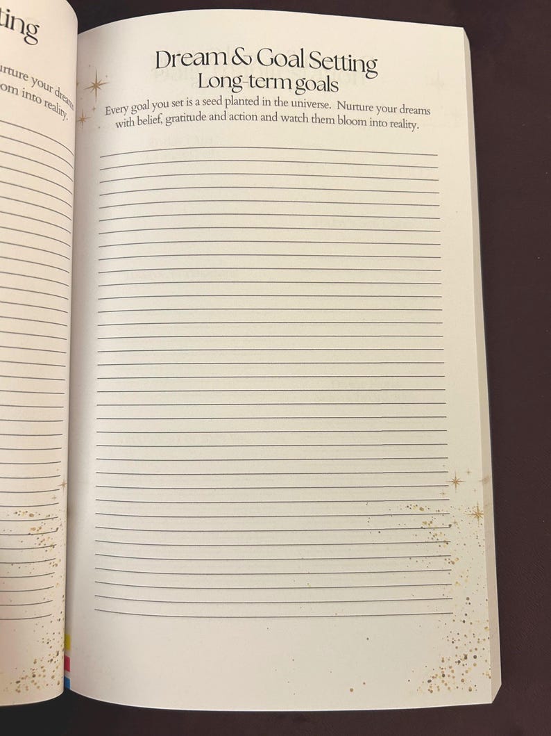 May include: Open notebook page with the heading "Dream & Goal Setting" and the subheading "Long-term goals." The text reads, "Every goal you set is a seed planted in the universe. Nurture your dreams with belief, gratitude and action and watch them bloom into reality."