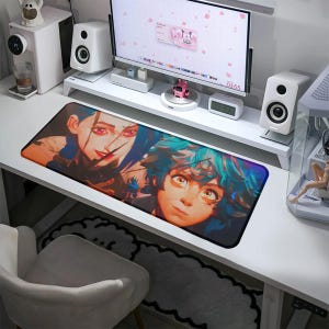 Può includere: Tappetino per mouse da gioco rettangolare con un'illustrazione colorata di due personaggi in stile anime con capelli blu e rossi. Il tappetino è progettato per essere posizionato su una scrivania e fornire una superficie liscia per il movimento del mouse. Il design è vibrante e dettagliato.