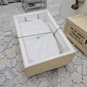 Calacatta Viola handmade stone sink securely placed in protective packaging, showing the basin prepared for safe shipping.