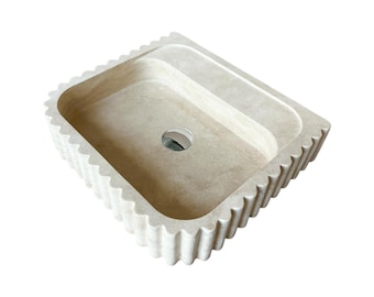 Lavabo in marmo travertino realizzato a mano: frontale scanalato, montaggio a parete.