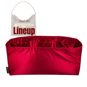 May include: A red satin handbag organizer with multiple compartments. The organizer is rectangular and designed to fit inside a larger bag. The image also shows a clear bag with the words "Made For Lineup" printed on it.