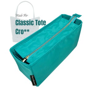 Może przedstawiać: Turkusowy organizer do torby typu tote z złotym zamkiem błyskawicznym. Organizer jest prostokątny i ma etykietę z napisem "PurzlInzerl". Obraz zawiera również biały kontur torby typu tote z tekstem "Made For Classic Tote Cro**".