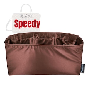 May include: A brown bag organiser with multiple compartments. The organiser is made of a smooth, satin-like material. The text "Made For Speedy" is visible in the background. A small tag with the text "PurzlInzert" is on the right side.