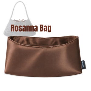 Puede incluir: Un organizador de bolso de satén marrón con acabado liso y una pequeña etiqueta negra en el lateral con la inscripción PurzInzert. Sobre el organizador, el contorno de un bolso con el texto Made For Rosanna Bag en letras marrones.