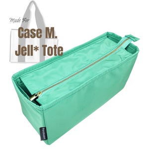 May include: A rectangular, light green tote bag organizer with a gold zipper closure. The text "Case M. Jell* Tote" is printed on the image. The organizer has a small pocket and the brand name "Purzlnzert" is printed on the bottom.