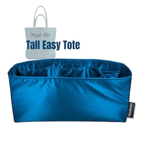 Può includere: Un organizer per borsa tote blu teal con più tasche interne. L'organizer è realizzato in un materiale lucido, simile al raso. Il testo "Made For Tall Easy Tote" è visibile nell'immagine.