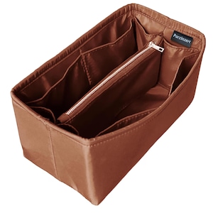 Pode incluir: Um organizador de bolsa marrom com vários compartimentos e uma seção central com zíper. O organizador tem formato retangular e é feito de um material liso semelhante ao couro. A marca "PurzInzert" é visível em uma pequena etiqueta.