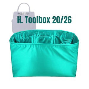 May include: A teal handbag organizer with multiple compartments. The organizer is designed to fit a H. Toolbox 20/26 bag. The text "Made For" and "H. Toolbox 20/26" is visible in the image.