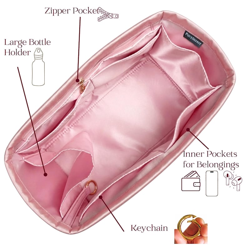 May include: Pink satin handbag organizer with multiple pockets, including a large bottle holder, zipper pocket, and inner pockets for belongings. Features a keychain ring. The organizer is designed to keep items organized.
