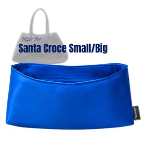 Op de afbeelding: Een levendige koningsblauwe tasorganizer met een gladde afwerking en een klein zwart zijlabel met het opschrift Purzlnzert. Boven het inzetstuk staat een vage omtrek van een tas met de tekst Made For Santa Croce Small/Big in donkerblauw.