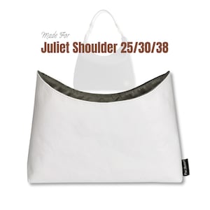 Könnte beinhalten: Weiße Schultertasche mit geschwungenem Oberteil und dunklem Innenfutter. Die Tasche ist mit "Made For Juliet Shoulder 25/30/38" beschriftet. Die Tasche hat ein schlichtes, modernes Design.