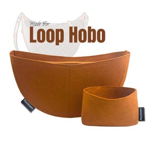 Puede incluir: Organizador de bolso de fieltro marrón de dos piezas para un bolso Loop Hobo. La pieza más grande tiene una cremallera y la más pequeña está abierta. El texto "Made For Loop Hobo" se muestra encima de los bolsos. La marca "Purzinzert" está en una etiqueta.