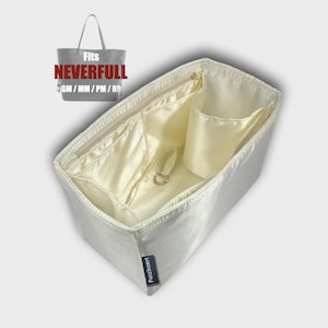 Op de afbeelding: Crèmekleurige handtassenorganizer met meerdere compartimenten, waaronder een vak met ritssluiting en een klein open vak. De organizer is ontworpen voor een Neverfull-tas, zoals aangegeven door de tekst in de afbeelding. De organizer heeft een rechthoekige vorm en is gemaakt van satijn.