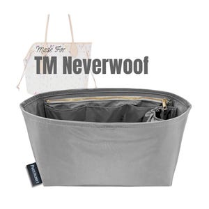 Puede incluir: Un organizador de bolso gris con múltiples compartimentos y una cremallera en la parte superior. El organizador tiene forma rectangular y está diseñado para caber dentro de un bolso tote más grande. El texto "TM Neverwoof" es visible.