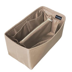 Op de afbeelding: Beige handtassenorganizer met meerdere compartimenten en een vak met ritssluiting. De organizer is rechthoekig en ontworpen om in een grotere tas te passen. De merknaam "PurzlInzert" is zichtbaar op een klein label.