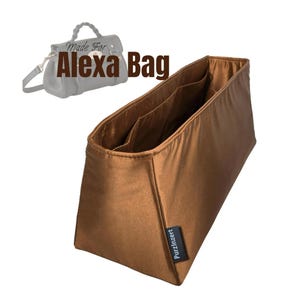 May include: A brown bag organizer with multiple interior pockets. The text "Made For Alexa Bag" is displayed above the organizer. A small black tag with the text "PurzInzert" is on the side of the organizer.