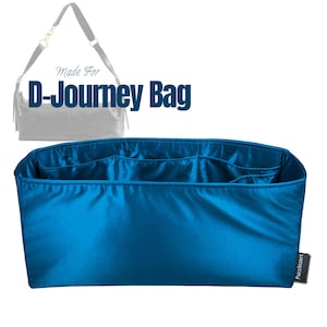 May include: A bright blue rectangular bag organizer insert with multiple interior pockets and a smooth finish. The text Made For D-Journey Bag appears above a faint outline of a handbag. A small black tag with white text is attached to the side.