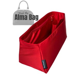 May include: A vibrant red bag organiser with several compartments, including a zipped pocket and smaller open pockets. The organiser is designed to fit inside an Alma bag, as indicated by the text "Made For Alma Bag" in the image.