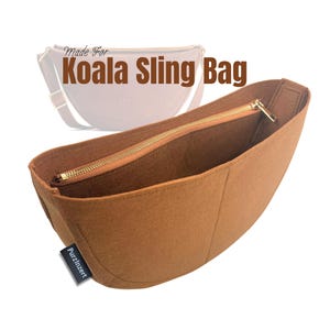 以下が含まれることがあります： ゴールドのジッパーが付いた、茶色のフェルト製Koala Sling Bagオーガナイザー。 オーガナイザーは、上部が湾曲した長方形の形状で、「PurzInzert」と書かれた小さな黒いタグが付いています。 背景には「Made For Koala Sling Bag」の文字があります。