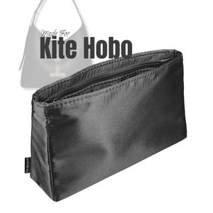 May include: A black, rectangular bag organizer with a zippered top. The text "Made For Kite Hobo" is displayed above the bag. The bag has a small, rectangular label on the side that reads "Purzinzert".