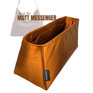May include: An orange-brown bag organiser with multiple interior pockets. The text "Made For MOTT MESSENGER" is visible at the top. A small black tag with the text "PurzInzert" is on the side. The organiser is designed to fit inside a messenger bag.