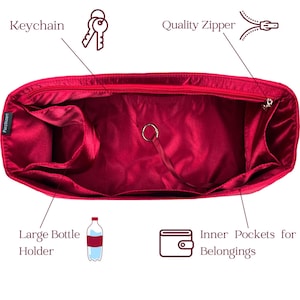 May include: A red handbag organizer with multiple compartments, including a large bottle holder and inner pockets. Features a quality zipper and a keychain attachment. The organizer is designed to keep belongings neatly arranged.