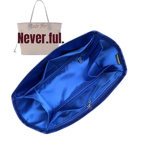 Peut inclure: Un organisateur de sac à main bleu avec plusieurs compartiments et une poche centrale zippée. L'organisateur est conçu pour être placé à l'intérieur d'un grand sac fourre-tout. Un sac fourre-tout beige séparé avec le texte "Made For Never.ful." est également visible.