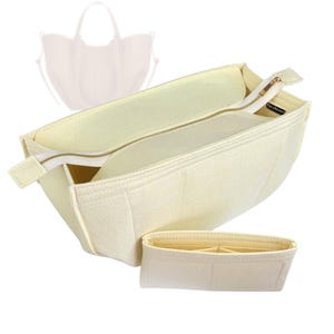 May include: Cream-colored felt bag organizer with a zippered main compartment and a smaller, separate organizer. The main compartment has a gold-colored zipper. The design includes a silhouette of a handbag in the background.